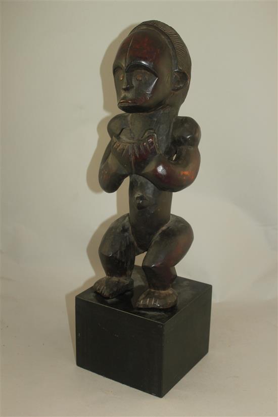 A West African carved hardwood figure of a seated male, overall 22in.